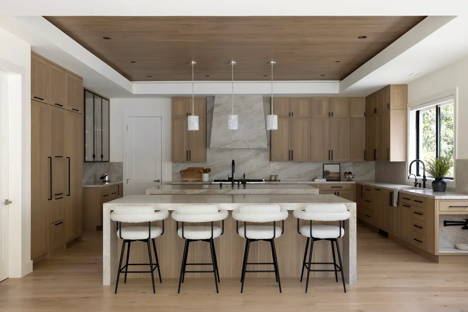 White-oak kitchen with waterfall stone island from a Los Altos full-home remodel